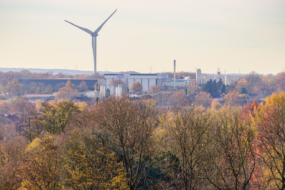 our-services-01 wind-turbine-above-autumn-trees-and-industrial-buildings-rmxmm9sabpe